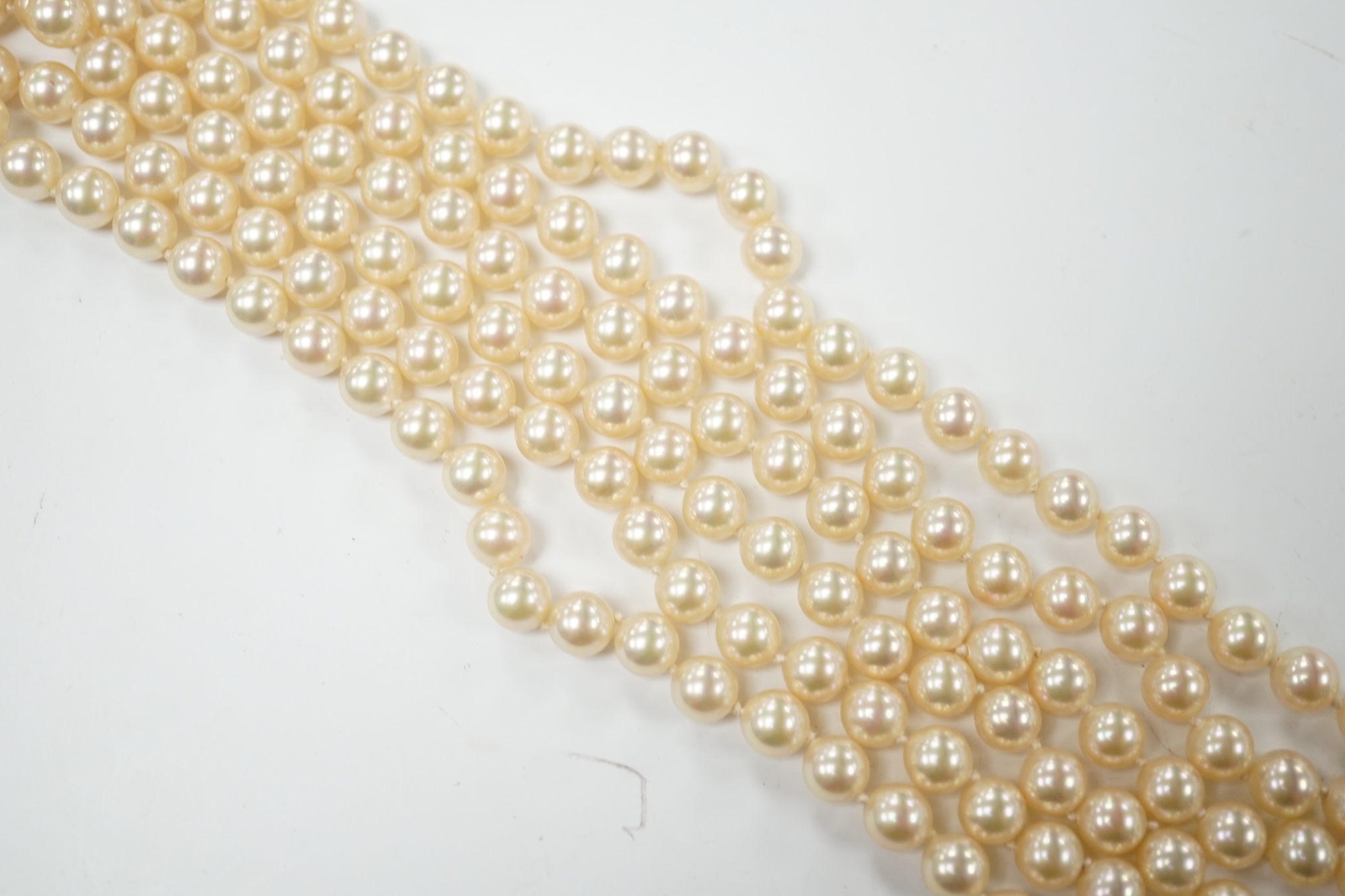 A late 1950's triple strand simulated pearl necklace, with garnet cluster set 9ct gold clasp, 66cm. Condition - fair